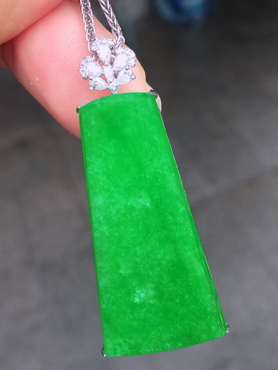 阳绿无事牌吊坠，色泽均匀艳丽，玉质细腻，荧光感超
强，饱满圆润，尽显优雅气质，18k
金豪华镶嵌