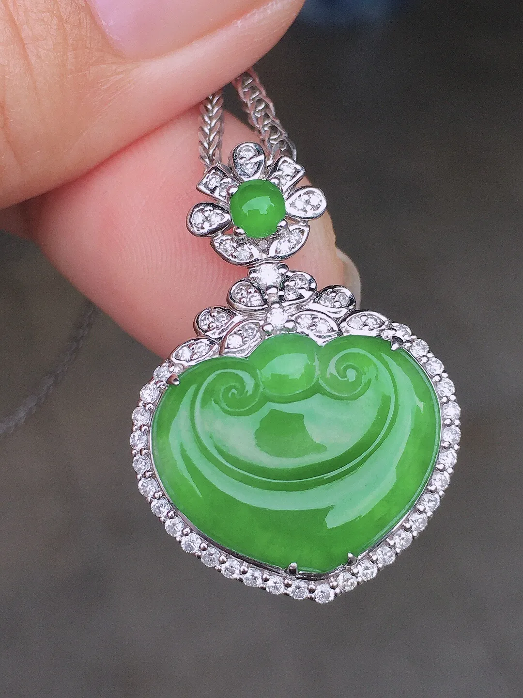 阳绿如意吊坠，色泽均匀艳丽，玉质细腻，荧光感超
强，饱满圆润，尽显优雅气质，18k
金豪华镶嵌