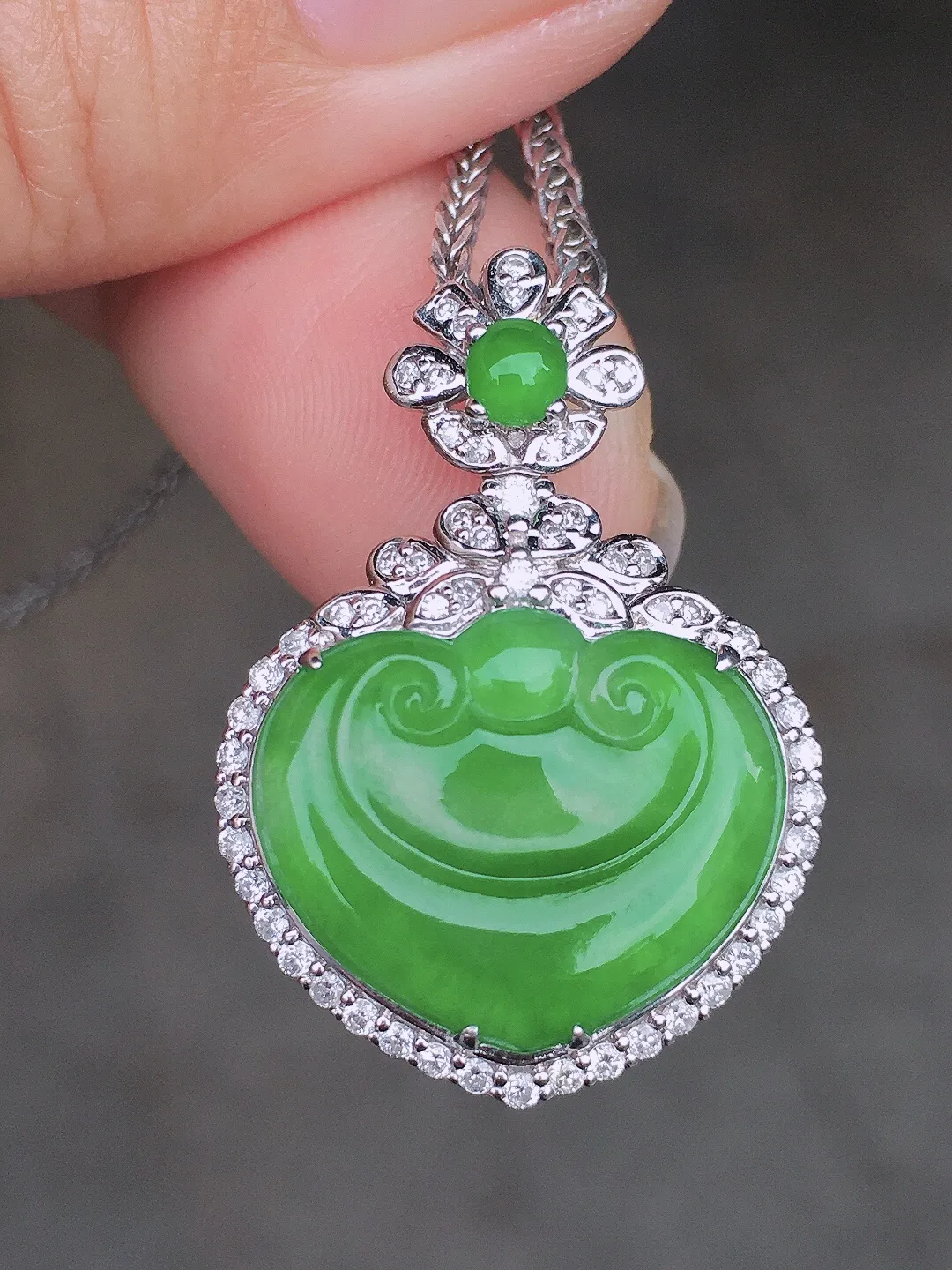 阳绿如意吊坠，色泽均匀艳丽，玉质细腻，荧光感超
强，饱满圆润，尽显优雅气质，18k
金豪华镶嵌