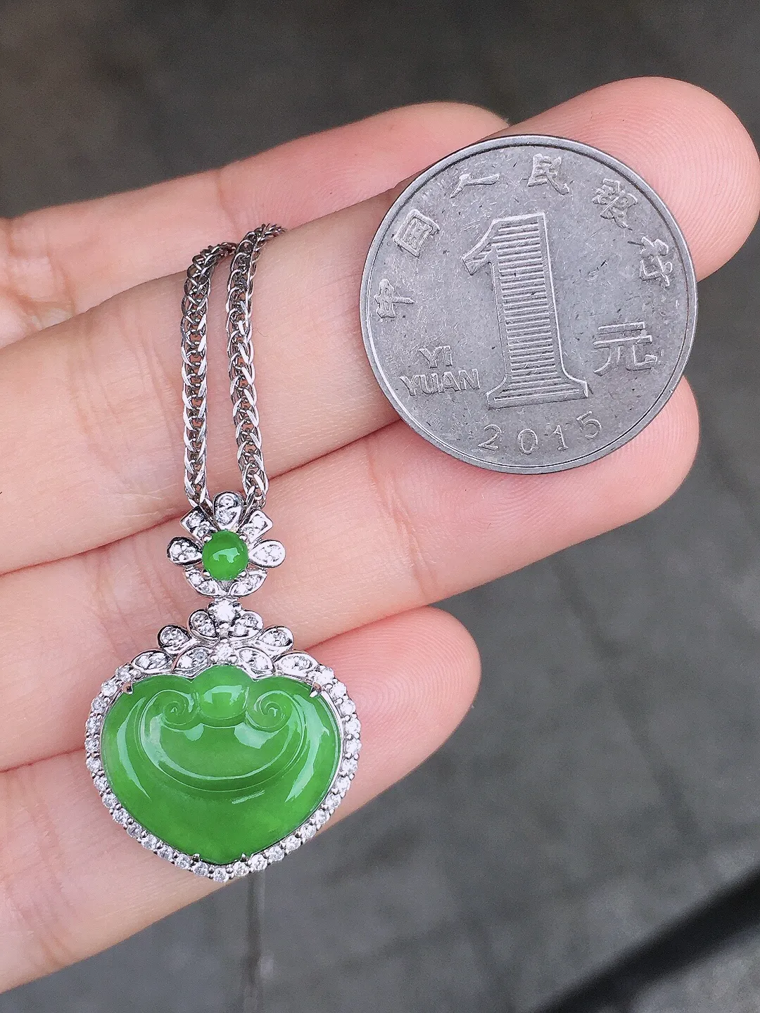 阳绿如意吊坠，色泽均匀艳丽，玉质细腻，荧光感超
强，饱满圆润，尽显优雅气质，18k
金豪华镶嵌