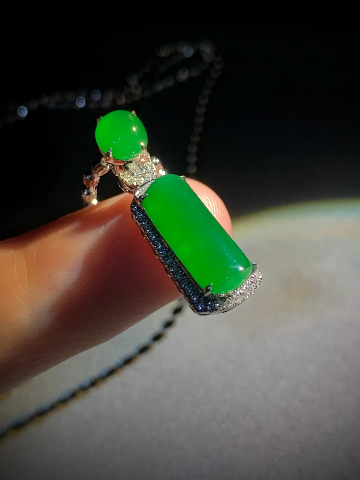 翡翠绿素面镶嵌吊坠，
裸石约14-6-3mm，6.5-5.6-2.5mm，
整体26.5-8.2-7.2mm，
18K金，南非钻，不配链子