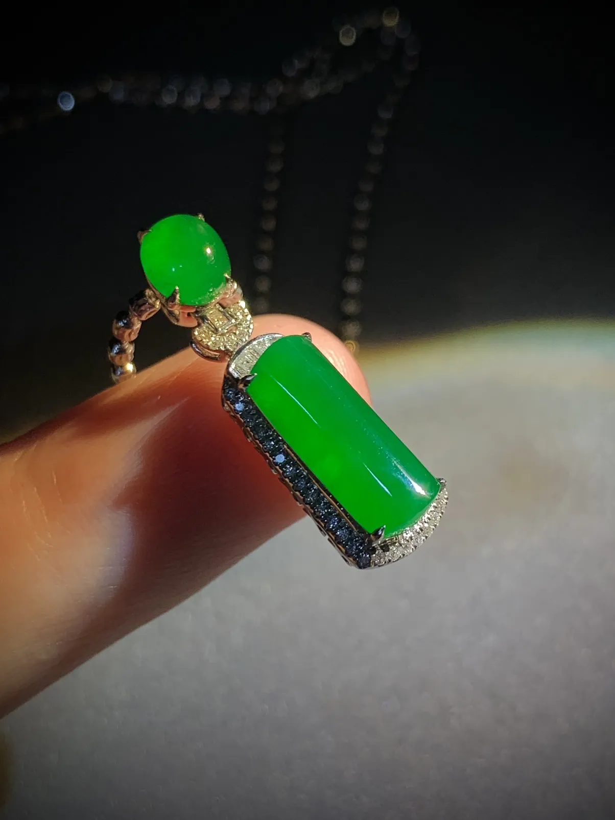 翡翠绿素面镶嵌吊坠，
裸石约14-6-3mm，6.5-5.6-2.5mm，
整体26.5-8.2-7.2mm，
18K金，南非钻，不配链子