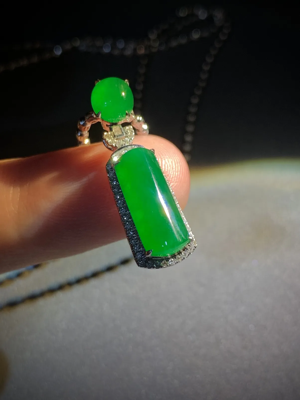 翡翠绿素面镶嵌吊坠，
裸石约14-6-3mm，6.5-5.6-2.5mm，
整体26.5-8.2-7.2mm，
18K金，南非钻，不配链子