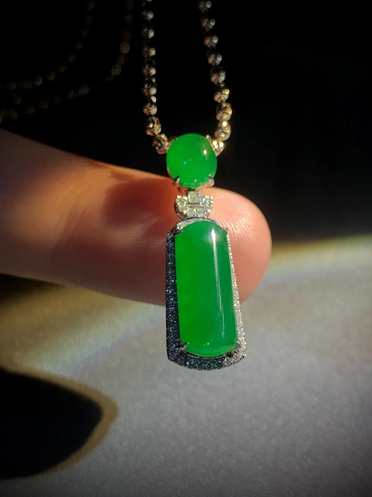 翡翠绿素面镶嵌吊坠，
裸石约14-6-3mm，6.5-5.6-2.5mm，
整体26.5-8.2-7