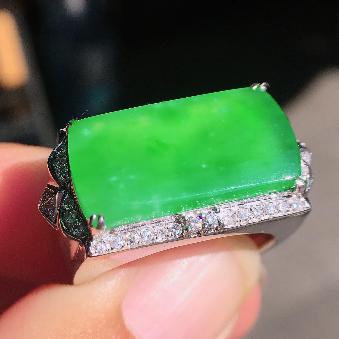 阳绿马鞍戒指，色泽均匀艳丽，玉质细腻，荧光感超
强，饱满圆润，尽显优雅气质，18k
金豪华镶嵌