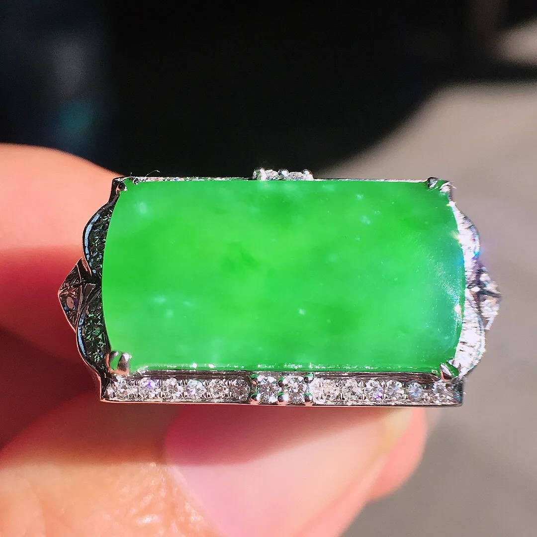 阳绿马鞍戒指，色泽均匀艳丽，玉质细腻，荧光感超
强，饱满圆润，尽显优雅气质，18k
金豪华镶嵌