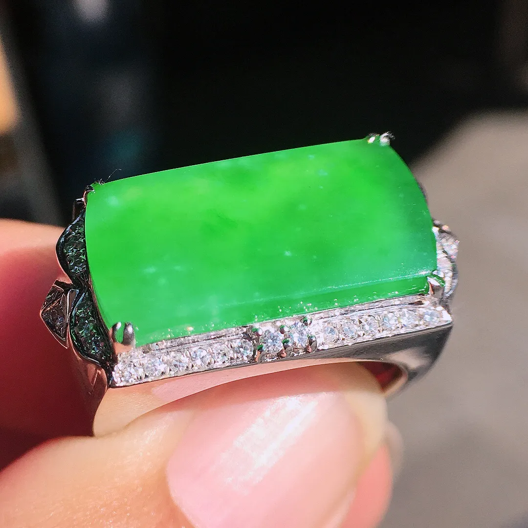 阳绿马鞍戒指，色泽均匀艳丽，玉质细腻，荧光感超
强，饱满圆润，尽显优雅气质，18k
金豪华镶嵌