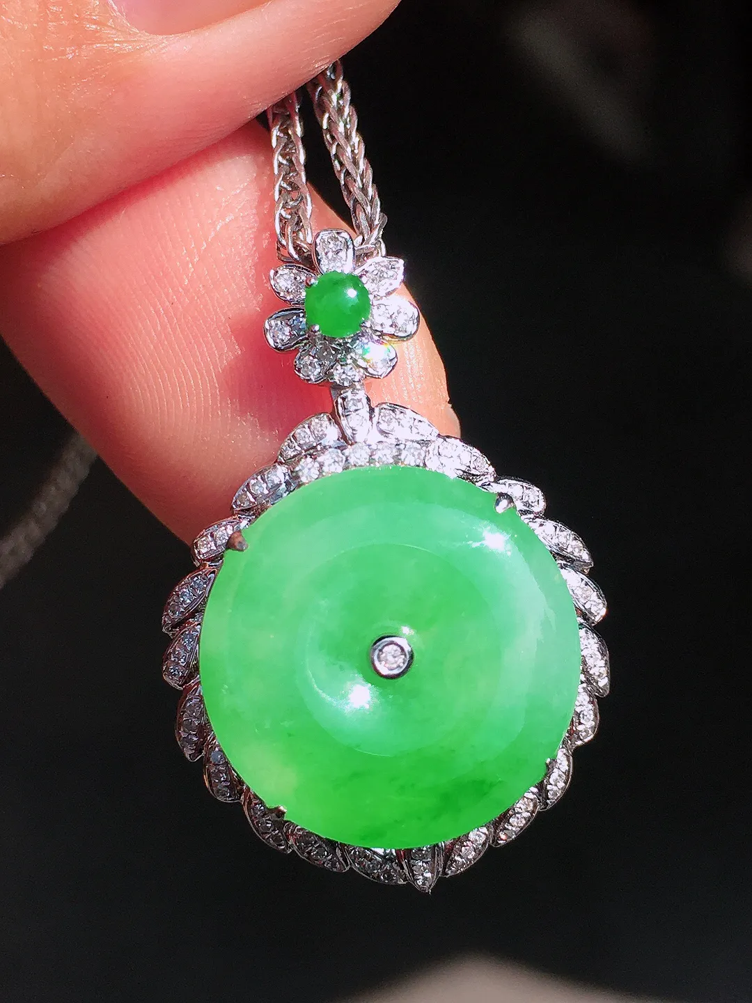 阳绿平安扣吊坠，色泽均匀艳丽，玉质细腻，荧光感超
强，饱满圆润，尽显优雅气质，18k
金豪华镶嵌