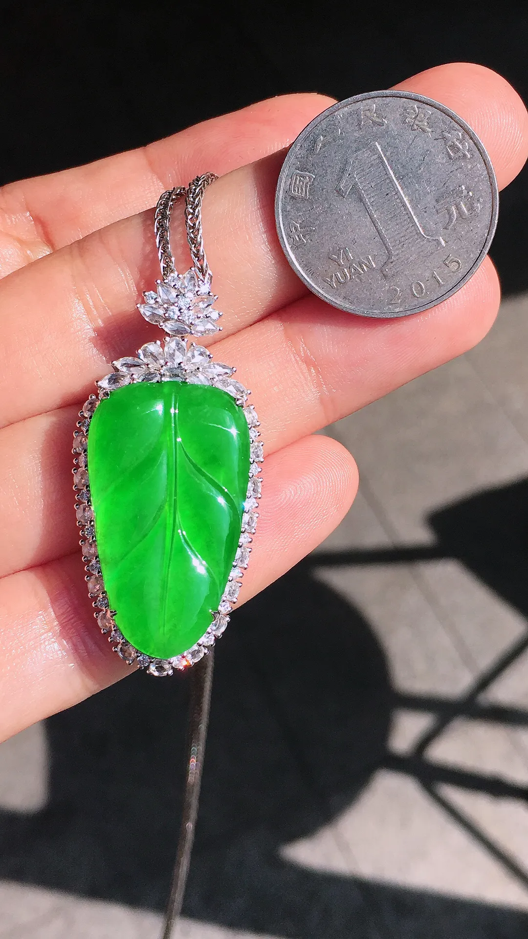 阳绿玉叶吊坠，色泽均匀艳丽，玉质细腻，荧光感超
强，饱满圆润，尽显优雅气质，18k
金豪华镶嵌