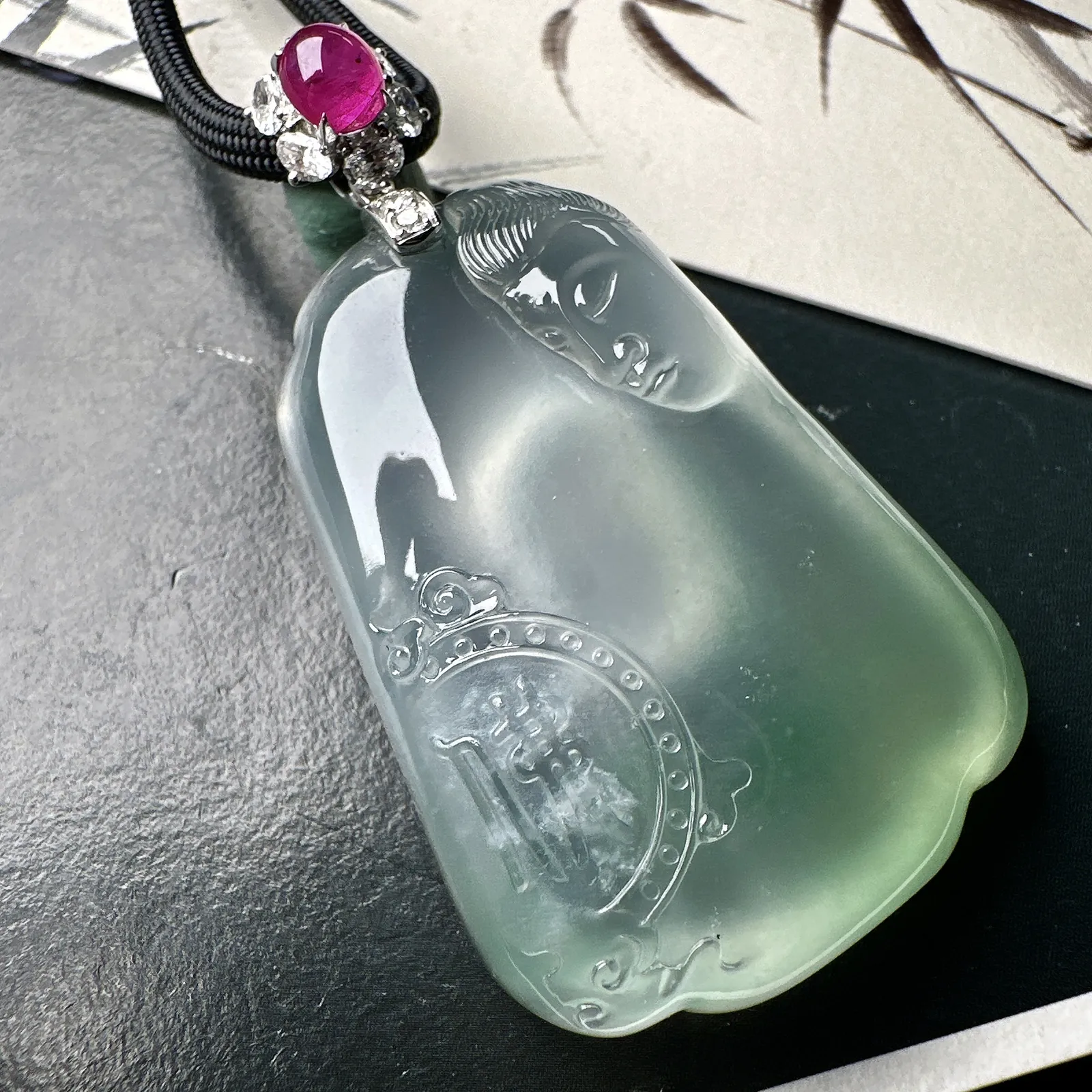 【冰种观音首吊坠】侧面像，料子通透闪亮，质地致密，种老起强胶感，玻璃光泽强烈。人物面部开脸生动，雕刻很精细，表情端庄祥和。料子纯净，18K金钻精美镶嵌，裸石尺寸44.2*31.2*10.7毫米