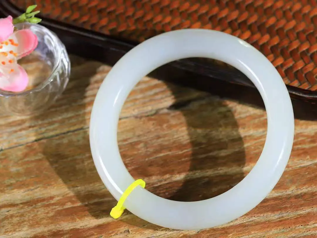 [温润如玉.手镯]

精品和田玉手镯。玉质温润细腻 油性十足 手感舒适，高华雅逸，线条流畅，简约大气，美自天成，素雅高贵。佩戴于腕间，婉约之美，举手投足间透出那份低调奢华。重64.6克 内径58.5mm尺寸11.7-10.3mm FDA-12110800