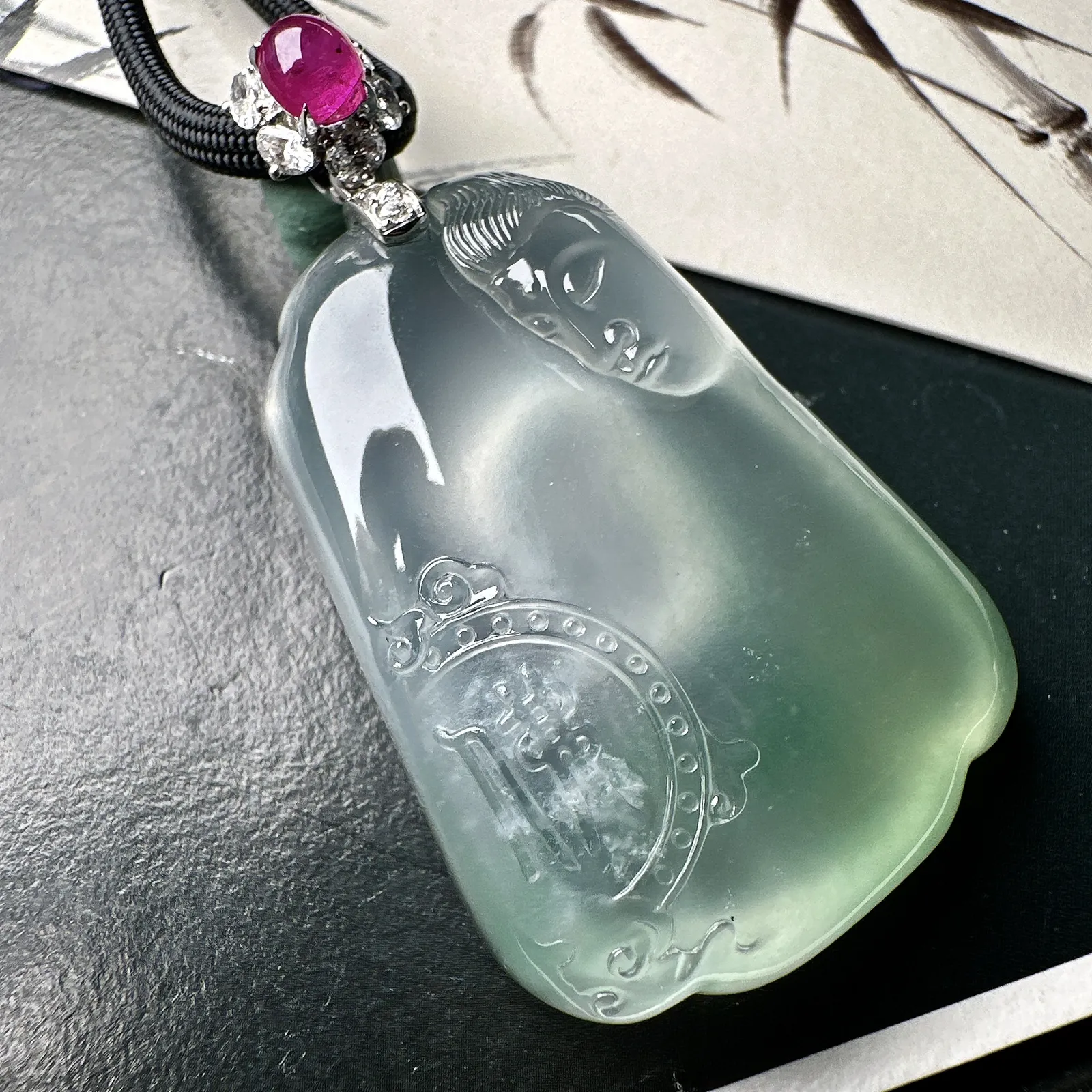 【冰种观音首吊坠】侧面像，料子通透闪亮，质地致密，种老起强胶感，玻璃光泽强烈。人物面部开脸生动，雕刻很精细，表情端庄祥和。料子纯净，18K金钻精美镶嵌，裸石尺寸44.2*31.2*10.7毫米