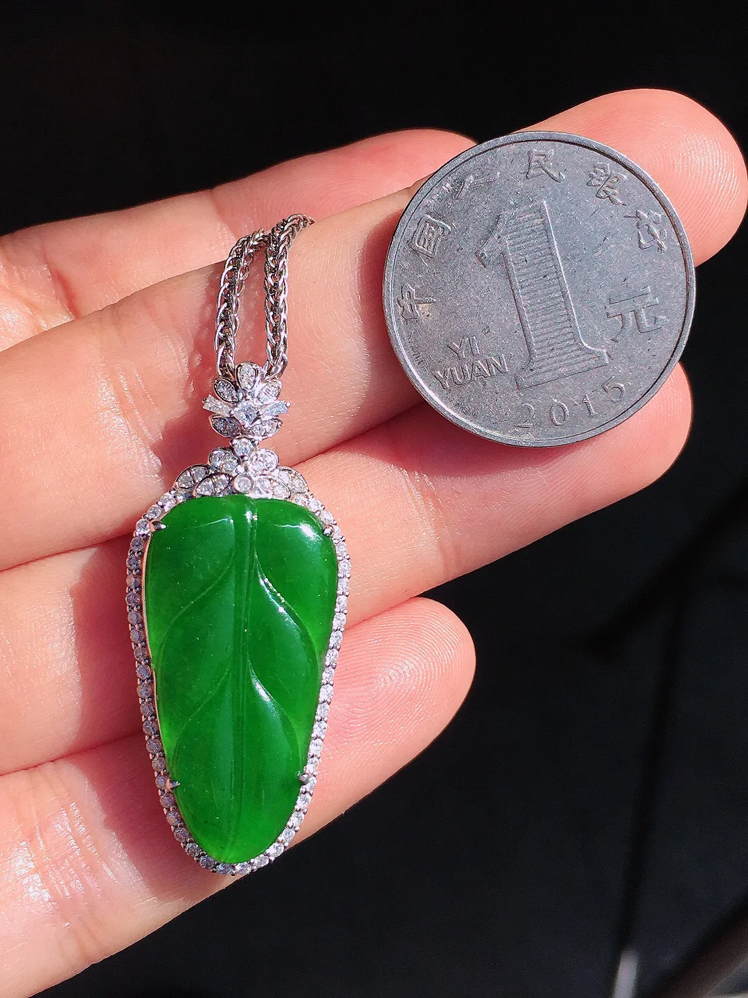 阳绿玉叶吊坠，色泽均匀艳丽，玉质细腻，荧光感超
强，饱满圆润，尽显优雅气质，18k
金豪华镶嵌