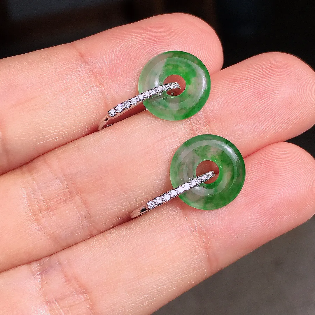 阳绿平安扣耳钉，色泽均匀艳丽，玉质细腻，荧光感超
强，饱满圆润，尽显优雅气质，18k
金豪华镶嵌