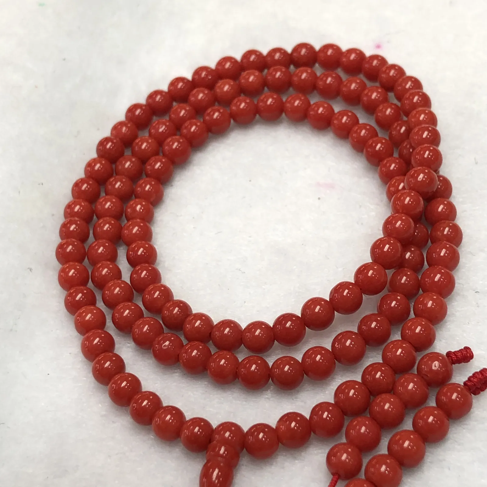 【天然4.5mm圆珠红珊瑚108佛珠串】牛血红色，颜色和品质都是喜人的，产自西班牙海域科西嘉岛，来自深海千年生长，自古被佛教奉为珍宝，底部为活动绳结，可拉到底，珠子尺寸4.5mm左右，重量为15.8克。珊瑚生长纹路清晰，材料稀少，个别有小虫眼，可忽略不计。收藏价值高！