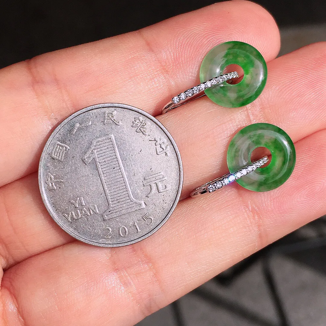 阳绿平安扣耳钉，色泽均匀艳丽，玉质细腻，荧光感超
强，饱满圆润，尽显优雅气质，18k
金豪华镶嵌