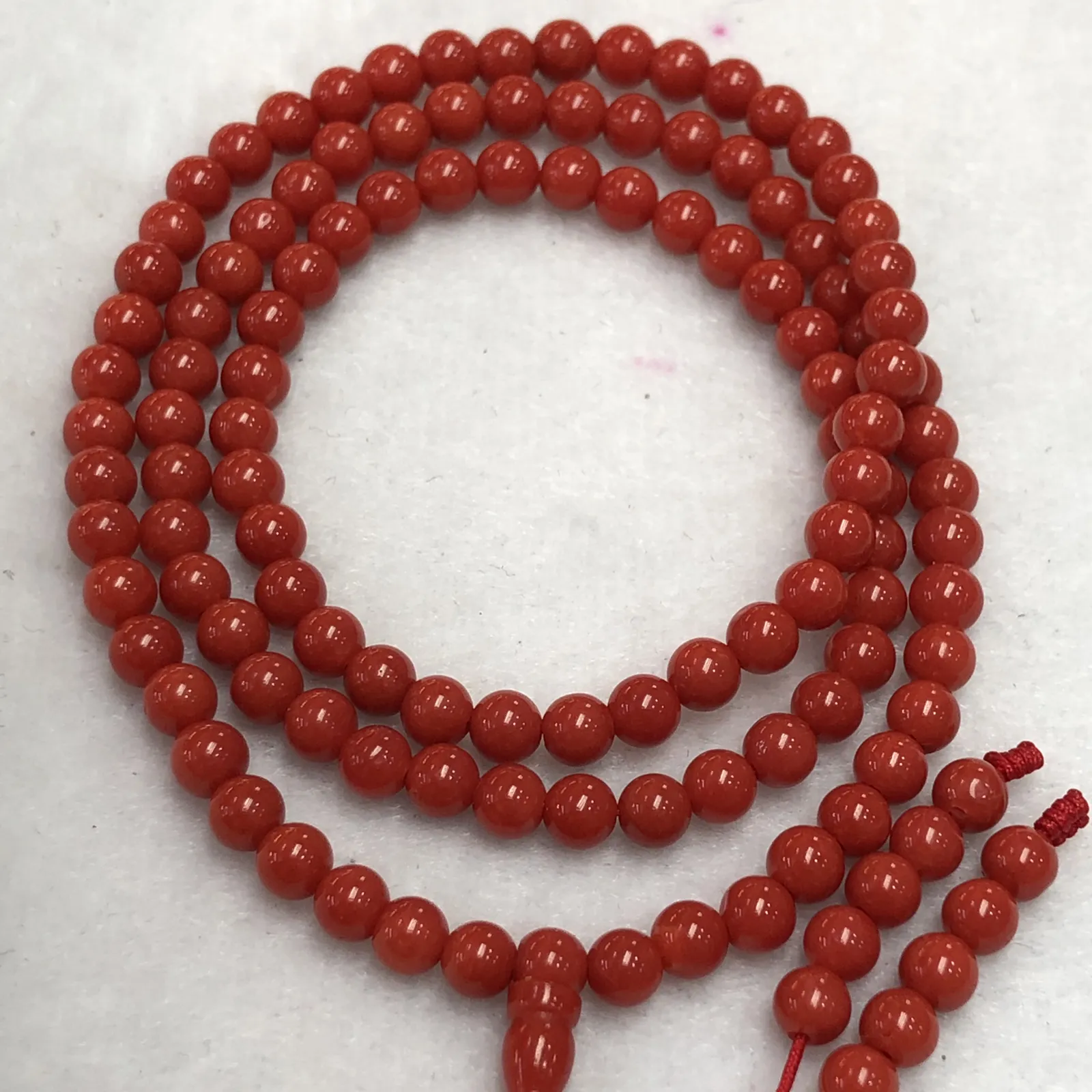 【天然4.5mm圆珠红珊瑚108佛珠串】牛血红色，颜色和品质都是喜人的，产自西班牙海域科西嘉岛，来自深海千年生长，自古被佛教奉为珍宝，底部为活动绳结，可拉到底，珠子尺寸4.5mm左右，重量为15.8克。珊瑚生长纹路清晰，材料稀少，个别有小虫眼，可忽略不计。收藏价值高！