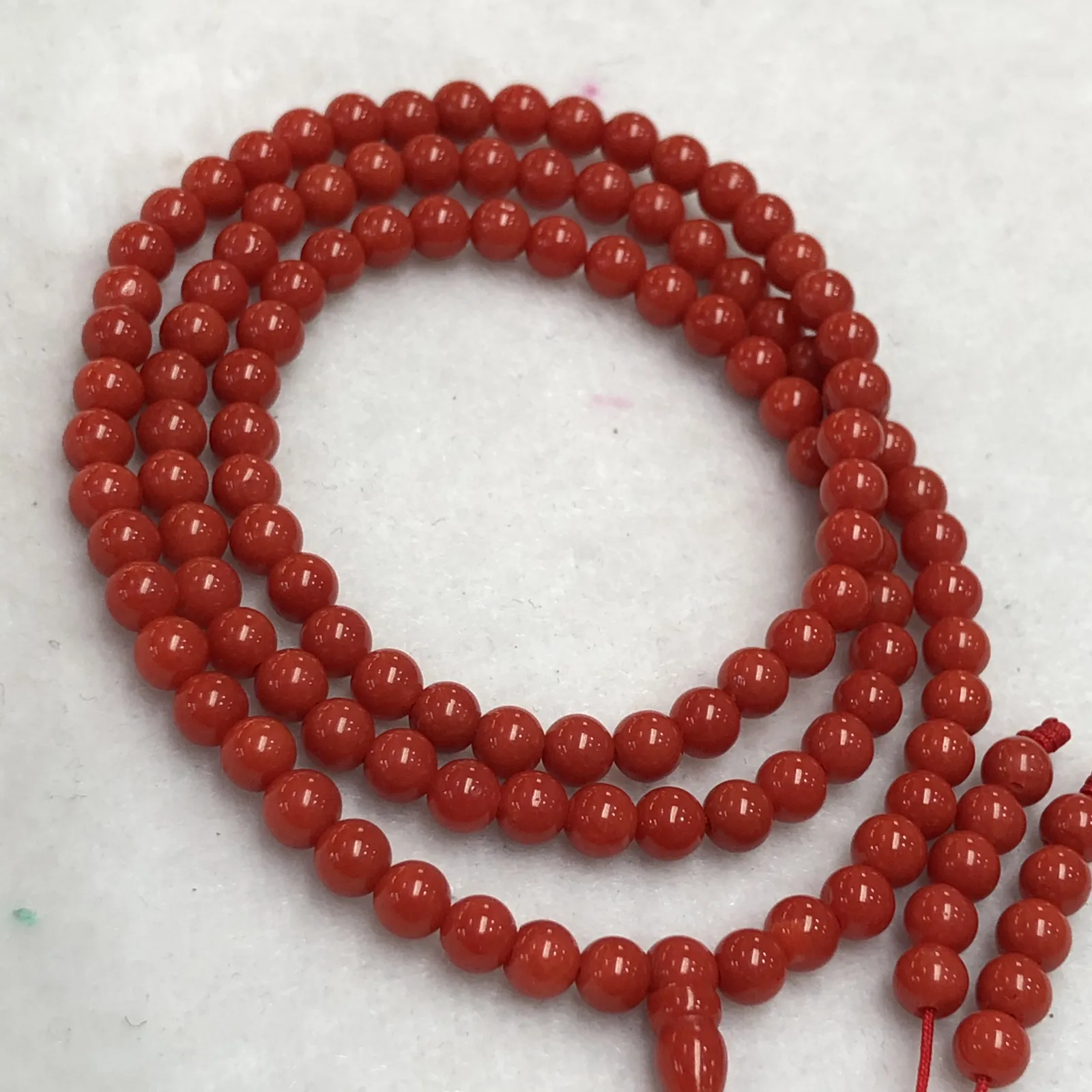 【天然4.5mm圆珠红珊瑚108佛珠串】牛血红色，颜色和品质都是喜人的，产自西班牙海域科西嘉岛，来自深海千年生长，自古被佛教奉为珍宝，底部为活动绳结，可拉到底，珠子尺寸4.5mm左右，重量为15.8克。珊瑚生长纹路清晰，材料稀少，个别有小虫眼，可忽略不计。收藏价值高！
