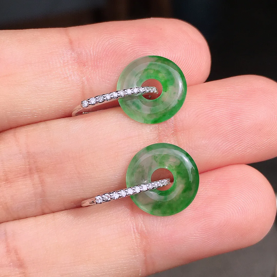 阳绿平安扣耳钉，色泽均匀艳丽，玉质细腻，荧光感超
强，饱满圆润，尽显优雅气质，18k
金豪华镶嵌