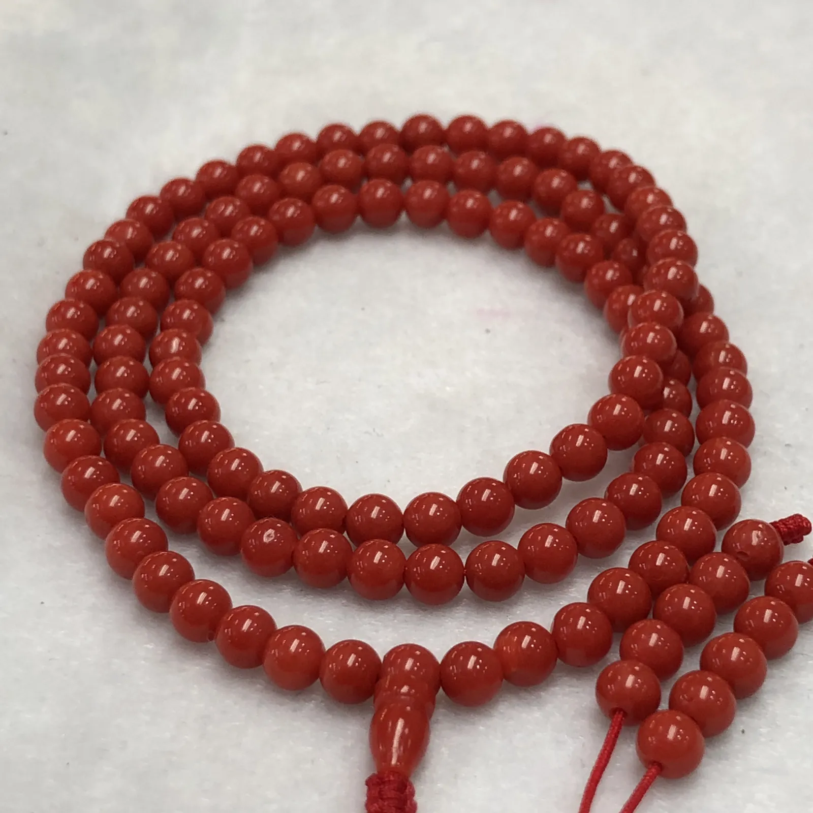 【天然4.5mm圆珠红珊瑚108佛珠串】牛血红色，颜色和品质都是喜人的，产自西班牙海域科西嘉岛，来自深海千年生长，自古被佛教奉为珍宝，底部为活动绳结，可拉到底，珠子尺寸4.5mm左右，重量为15.8克。珊瑚生长纹路清晰，材料稀少，个别有小虫眼，可忽略不计。收藏价值高！