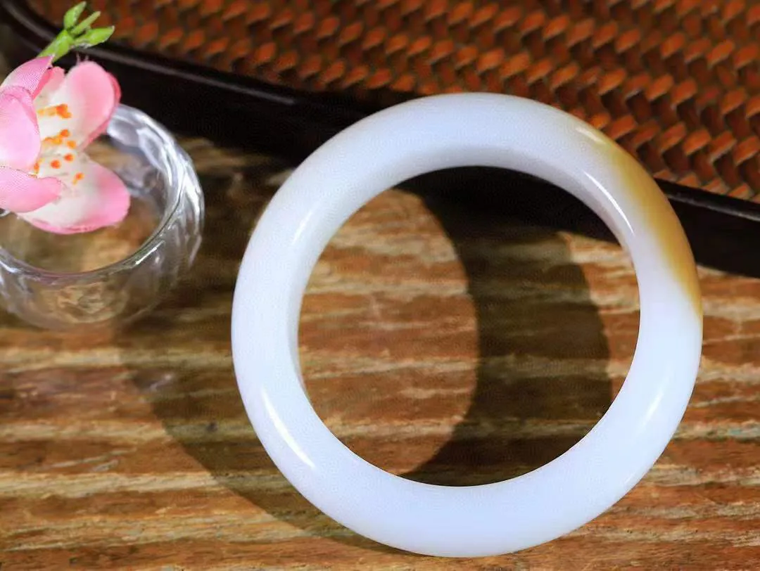 （一见钟情.手镯）

收藏级臻品️和田玉糖白玉手镯，玉质温和莹润，精光内蕴，手感舒适。整器简约，打磨光洁，让人爱不释手，料美艺精，萦绕于手，尽显高贵之姿。重73克 内径54.5mm尺寸15.5-9.7mm   FDA-101101073