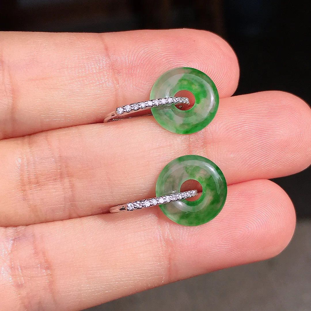 阳绿平安扣耳钉，色泽均匀艳丽，玉质细腻，荧光感超
强，饱满圆润，尽显优雅气质，18k
金豪华镶嵌