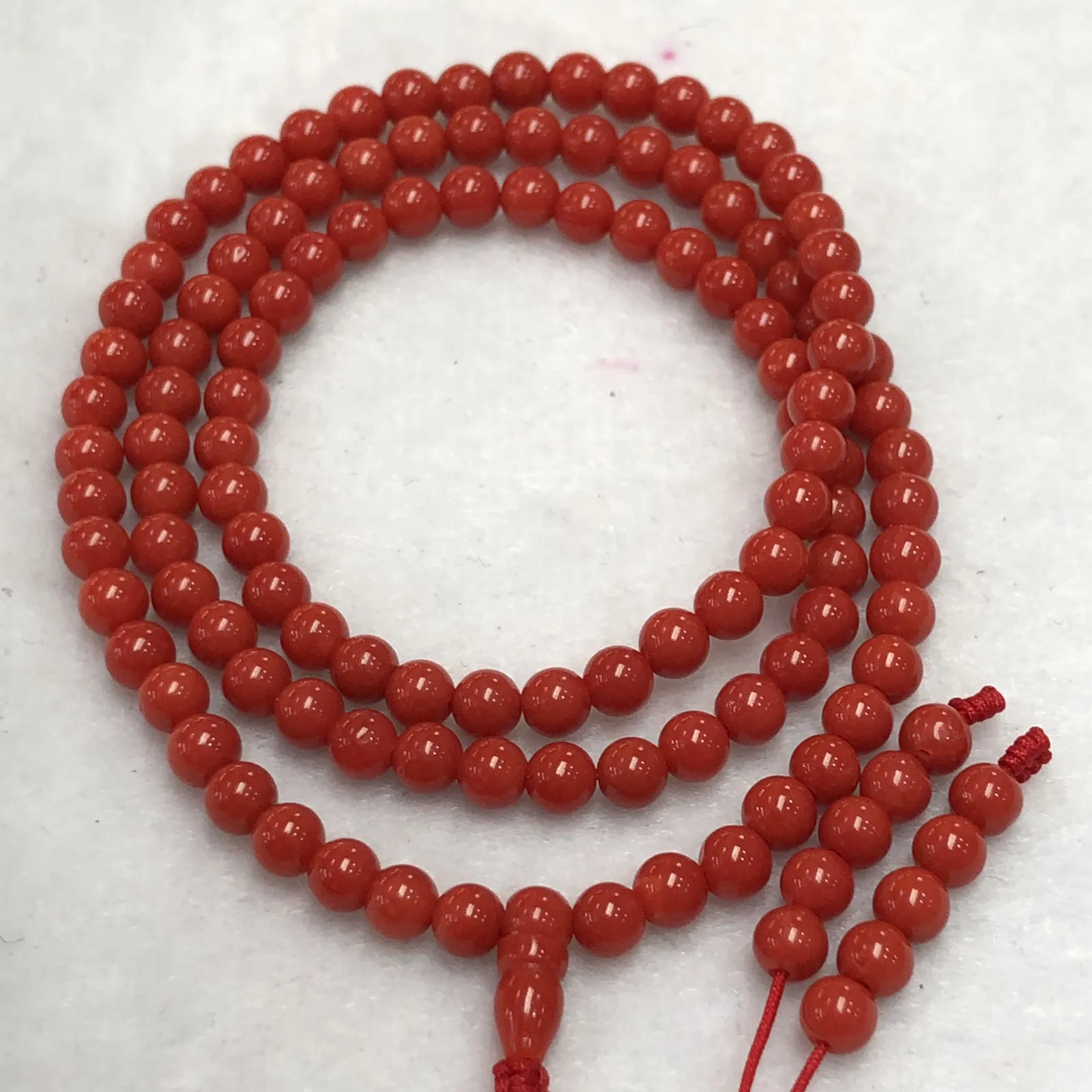【天然4.5mm圆珠红珊瑚108佛珠串】牛血红色，颜色和品质都是喜人的，产自西班牙海域科西嘉岛，来自深海千年生长，自古被佛教奉为珍宝，底部为活动绳结，可拉到底，珠子尺寸4.5mm左右，重量为15.8克。珊瑚生长纹路清晰，材料稀少，个别有小虫眼，可忽略不计。收藏价值高！