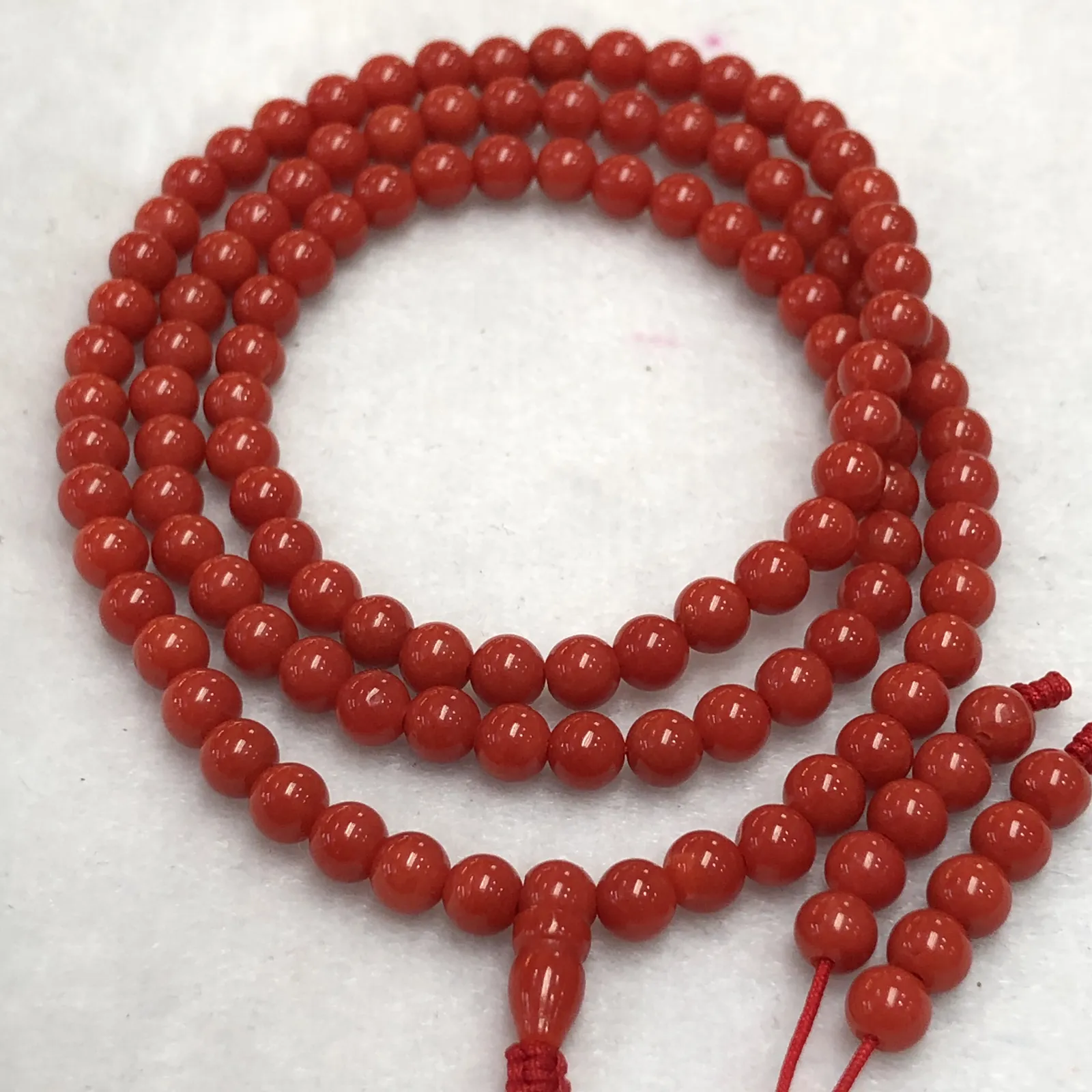 【天然4.5mm圆珠红珊瑚108佛珠串】牛血红色，颜色和品质都是喜人的，产自西班牙海域科西嘉岛，来自深海千年生长，自古被佛教奉为珍宝，底部为活动绳结，可拉到底，珠子尺寸4.5mm左右，重量为15.8克。珊瑚生长纹路清晰，材料稀少，个别有小虫眼，可忽略不计。收藏价值高！