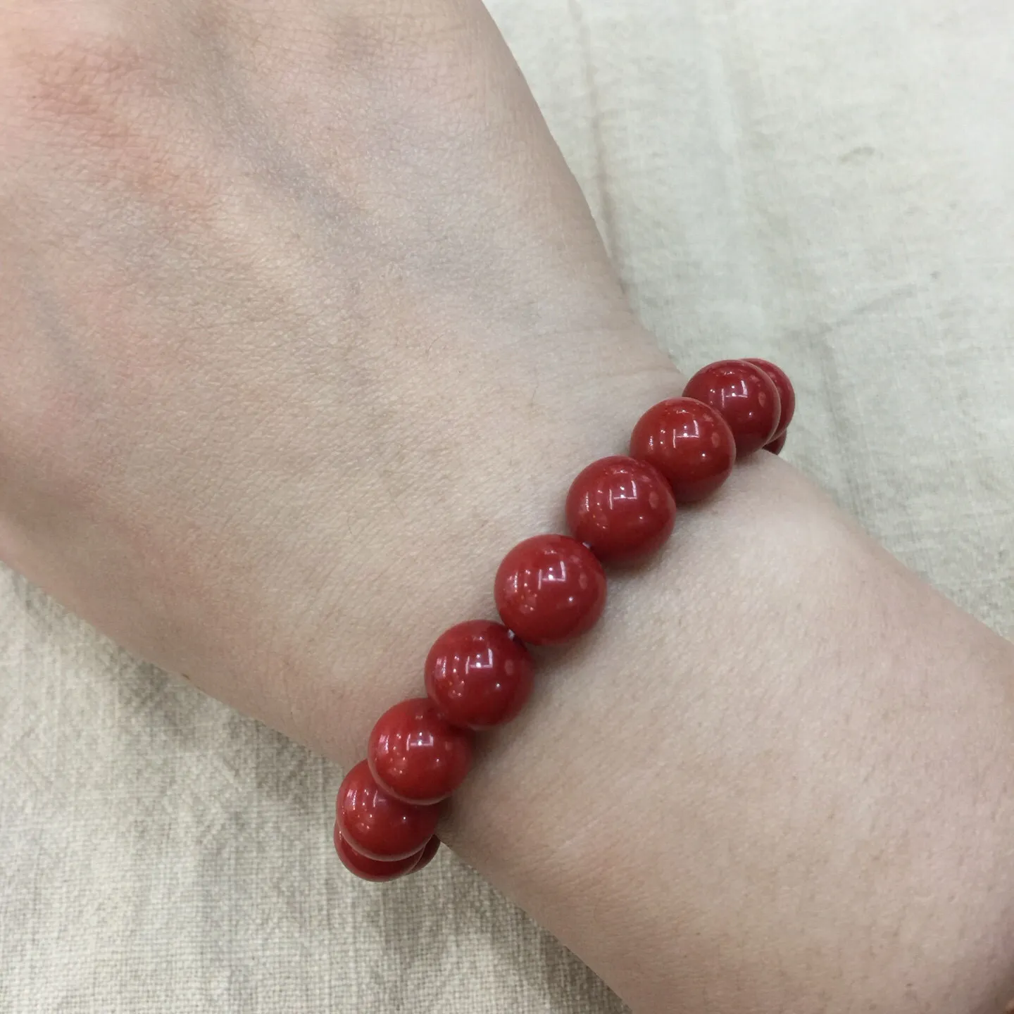 【天然近牛血珊瑚10mm大圆珠弹力手串】近牛血红颜色，光泽柔润透亮，直径约为10.15-9.36mm，重量为23.48克，珊瑚本为佛教珍宝，来自深海千年生长，有生长纹，属于有机宝石，气场强大，材料意大利沙丁材料，稀少珍贵！每粒均为天然无添加无修补！收藏精品！传承宝贝！