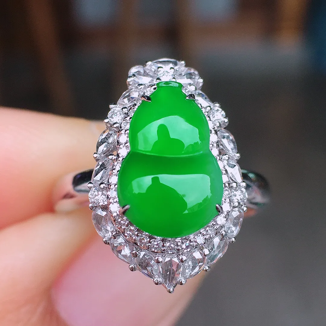 阳绿葫芦戒指，色泽均匀艳丽，玉质细腻，荧光感超
强，饱满圆润，尽显优雅气质，18k
金豪华镶嵌