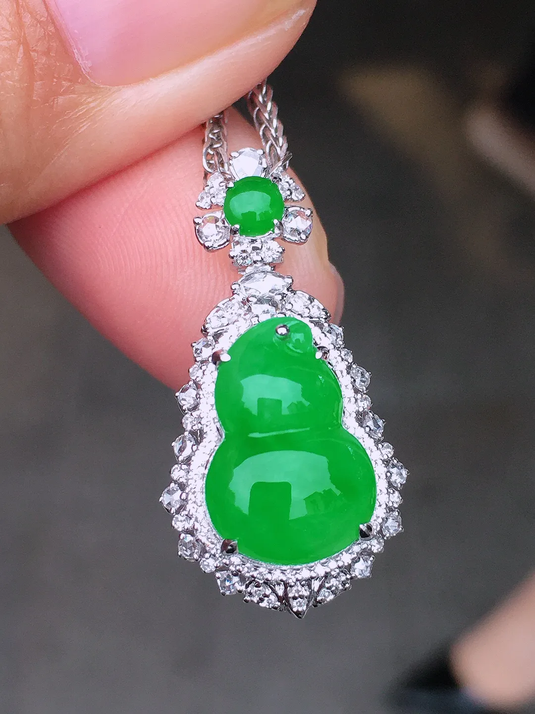 阳绿葫芦吊坠，色泽均匀艳丽，玉质细腻，荧光感超
强，饱满圆润，尽显优雅气质，18k
金豪华镶嵌