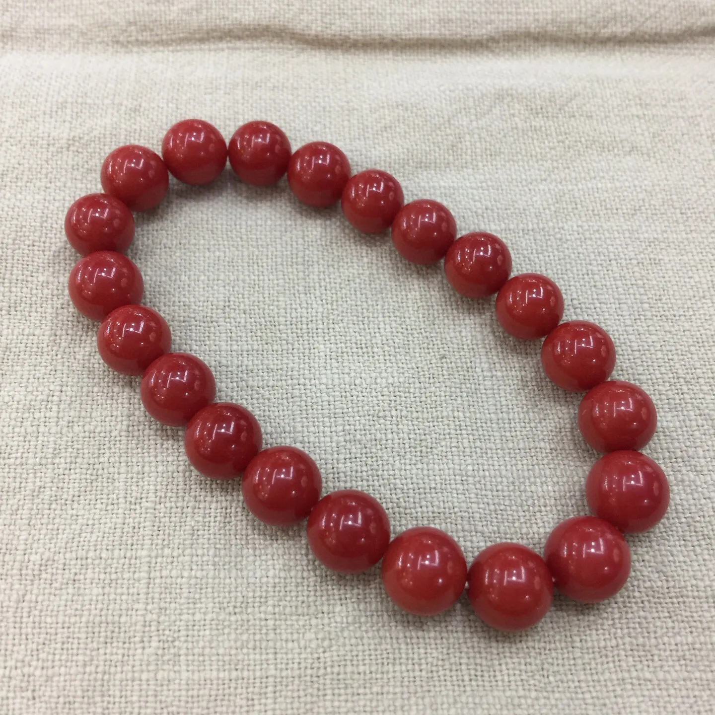 【天然近牛血珊瑚9.28mm大圆珠弹力手串】近牛血红颜色，光泽柔润透亮，直径约为9.28-8.5mm，重量为20.59克，珊瑚本为佛教珍宝，来自深海千年生长，有生长纹，属于有机宝石，气场强大，材料意大利沙丁材料，稀少珍贵！每粒均为天然无添加无修补！收藏精品！传承宝贝！