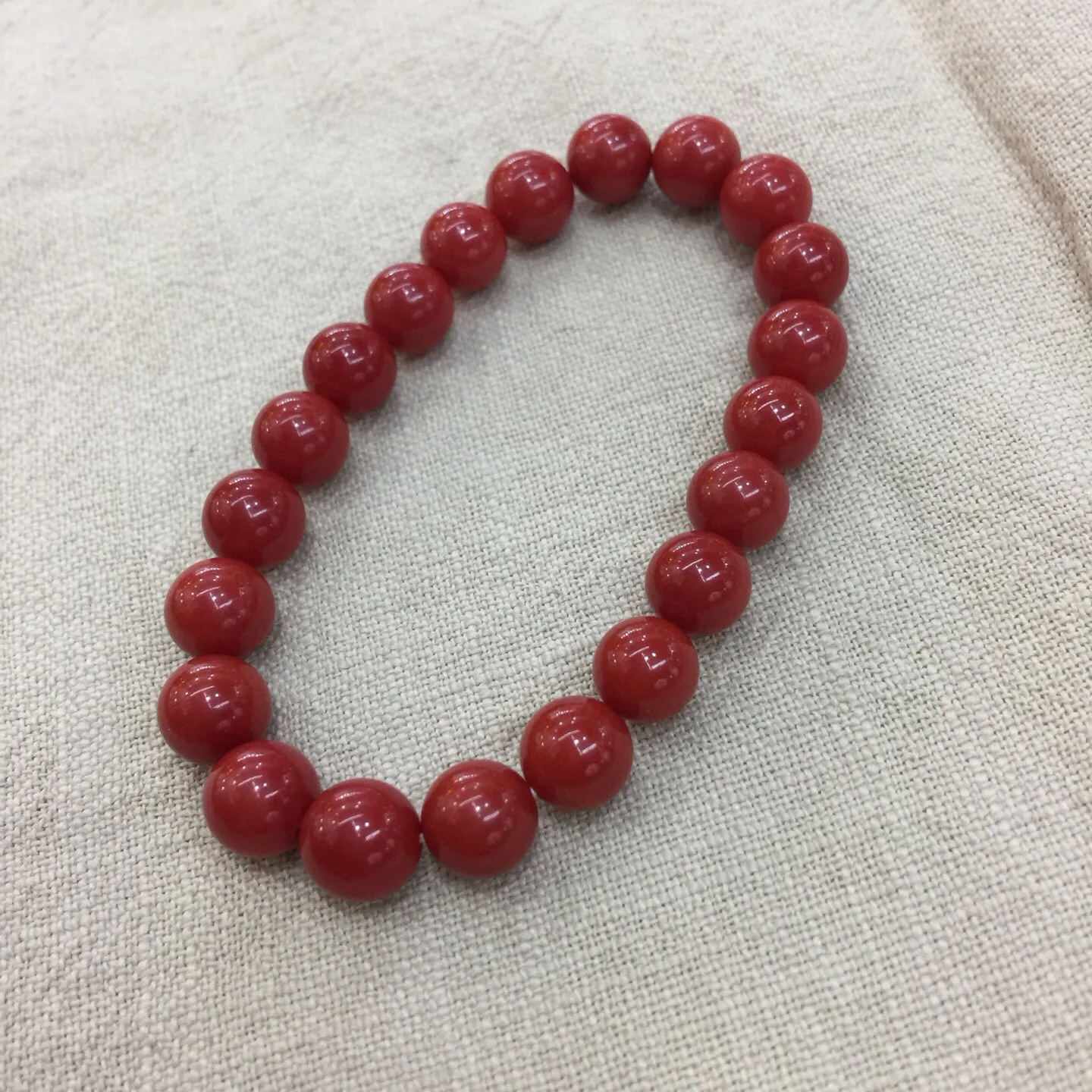 【天然近牛血珊瑚9.28mm大圆珠弹力手串】近牛血红颜色，光泽柔润透亮，直径约为9.28-8.5mm，重量为20.59克，珊瑚本为佛教珍宝，来自深海千年生长，有生长纹，属于有机宝石，气场强大，材料意大利沙丁材料，稀少珍贵！每粒均为天然无添加无修补！收藏精品！传承宝贝！