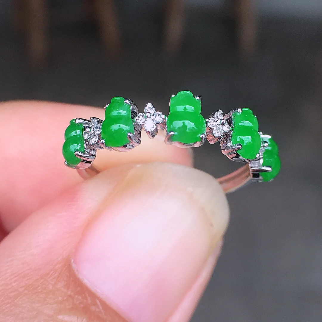 阳绿葫芦排戒指，色泽均匀艳丽，玉质细腻，荧光感超
强，饱满圆润，尽显优雅气质，18k
金豪华镶嵌