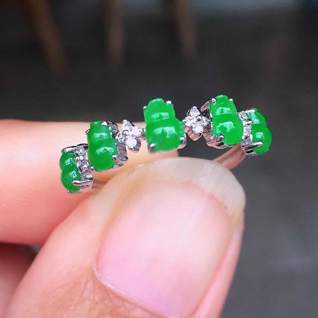 阳绿葫芦排戒指，色泽均匀艳丽，玉质细腻，荧光感超
强，饱满圆润，尽显优雅气质，18k
金豪华镶嵌