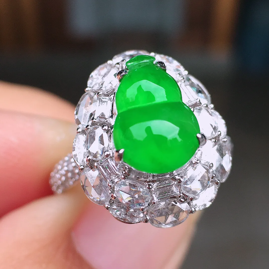 阳绿葫芦戒指，色泽均匀艳丽，玉质细腻，荧光感超
强，饱满圆润，尽显优雅气质，18k
金豪华镶嵌