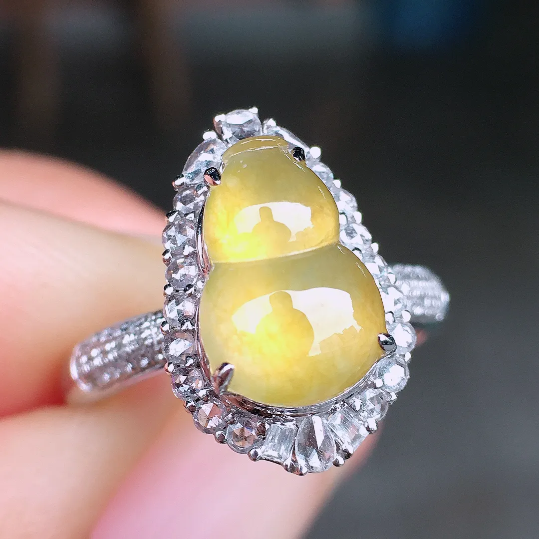 黄翡葫芦戒指，色泽均匀艳丽，玉质细腻，荧光感超
强，饱满圆润，尽显优雅气质，18k
金豪华镶嵌