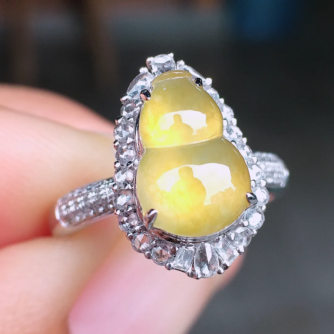 黄翡葫芦戒指，色泽均匀艳丽，玉质细腻，荧光感超
强，饱满圆润，尽显优雅气质，18k
金豪华镶嵌