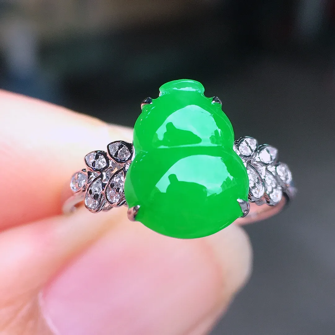 阳绿葫芦戒指，色泽均匀艳丽，玉质细腻，荧光感超
强，饱满圆润，尽显优雅气质，18k
金豪华镶嵌