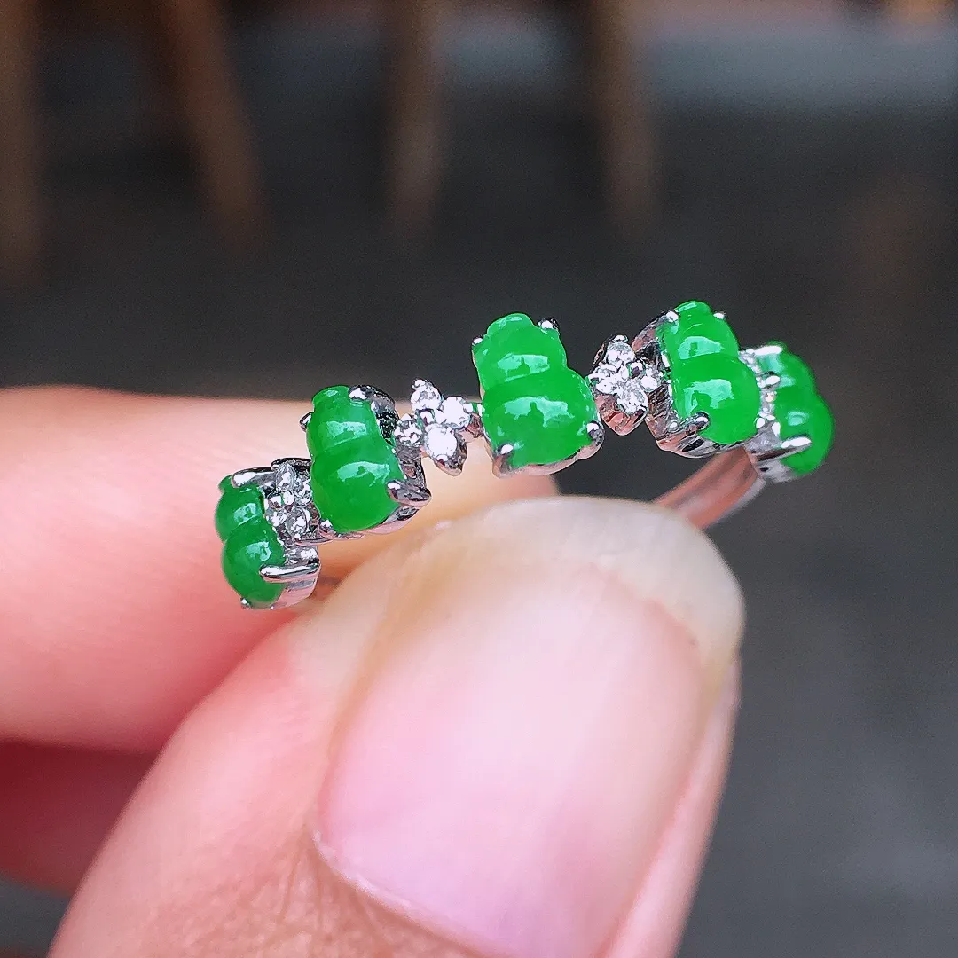 阳绿葫芦排戒指，色泽均匀艳丽，玉质细腻，荧光感超
强，饱满圆润，尽显优雅气质，18k
金豪华镶嵌