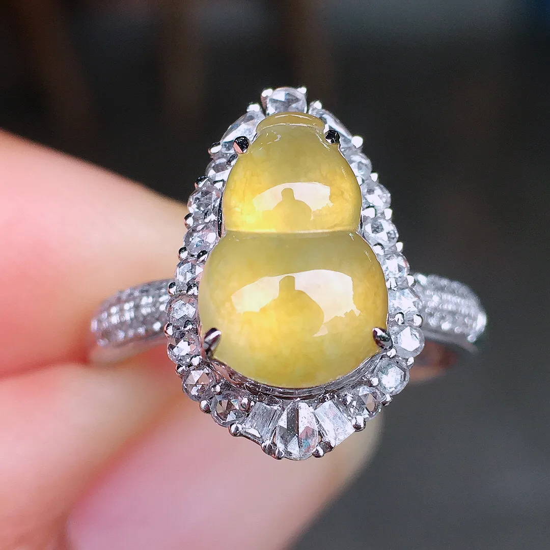 黄翡葫芦戒指，色泽均匀艳丽，玉质细腻，荧光感超
强，饱满圆润，尽显优雅气质，18k
金豪华镶嵌