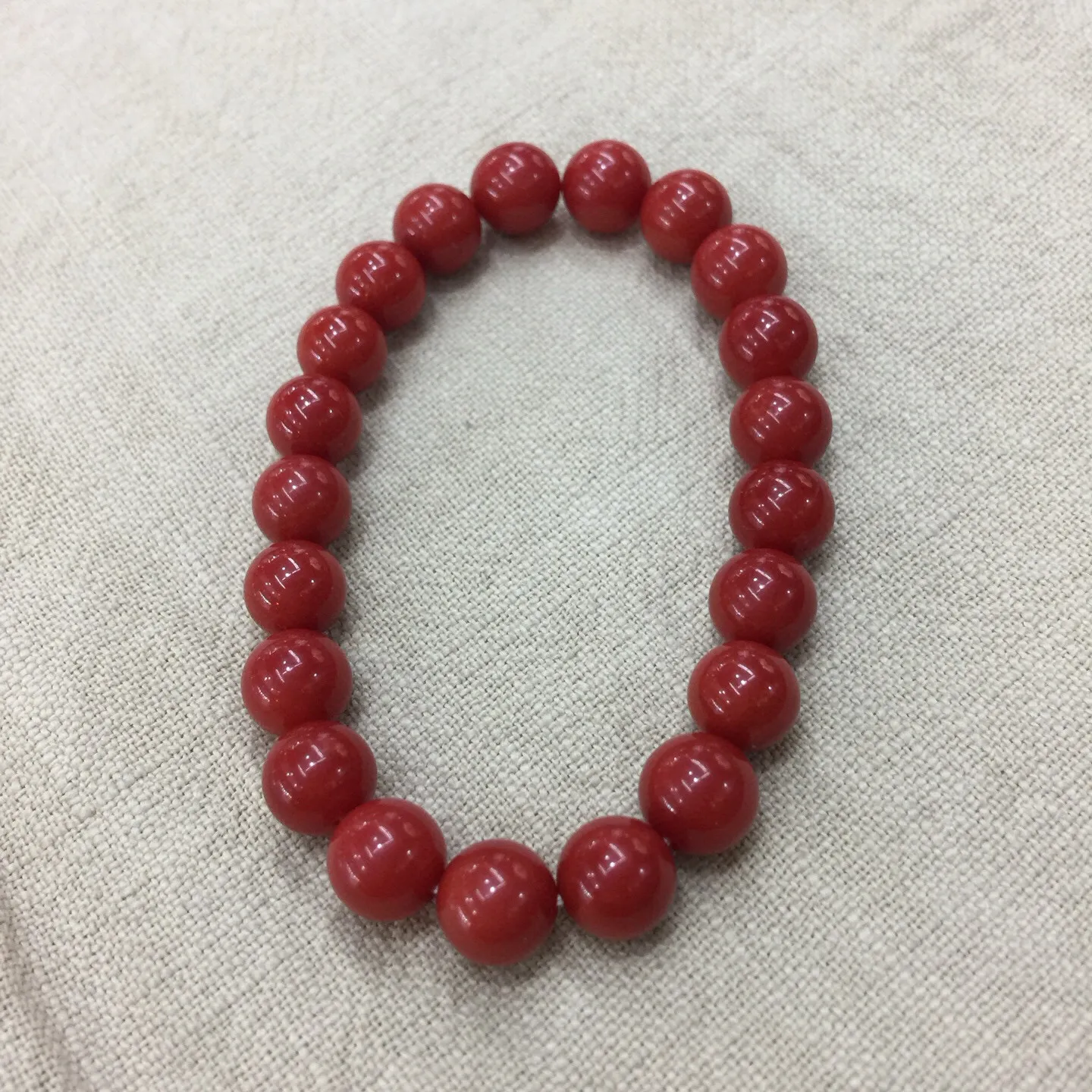 【天然近牛血珊瑚9.28mm大圆珠弹力手串】近牛血红颜色，光泽柔润透亮，直径约为9.28-8.5mm，重量为20.59克，珊瑚本为佛教珍宝，来自深海千年生长，有生长纹，属于有机宝石，气场强大，材料意大利沙丁材料，稀少珍贵！每粒均为天然无添加无修补！收藏精品！传承宝贝！