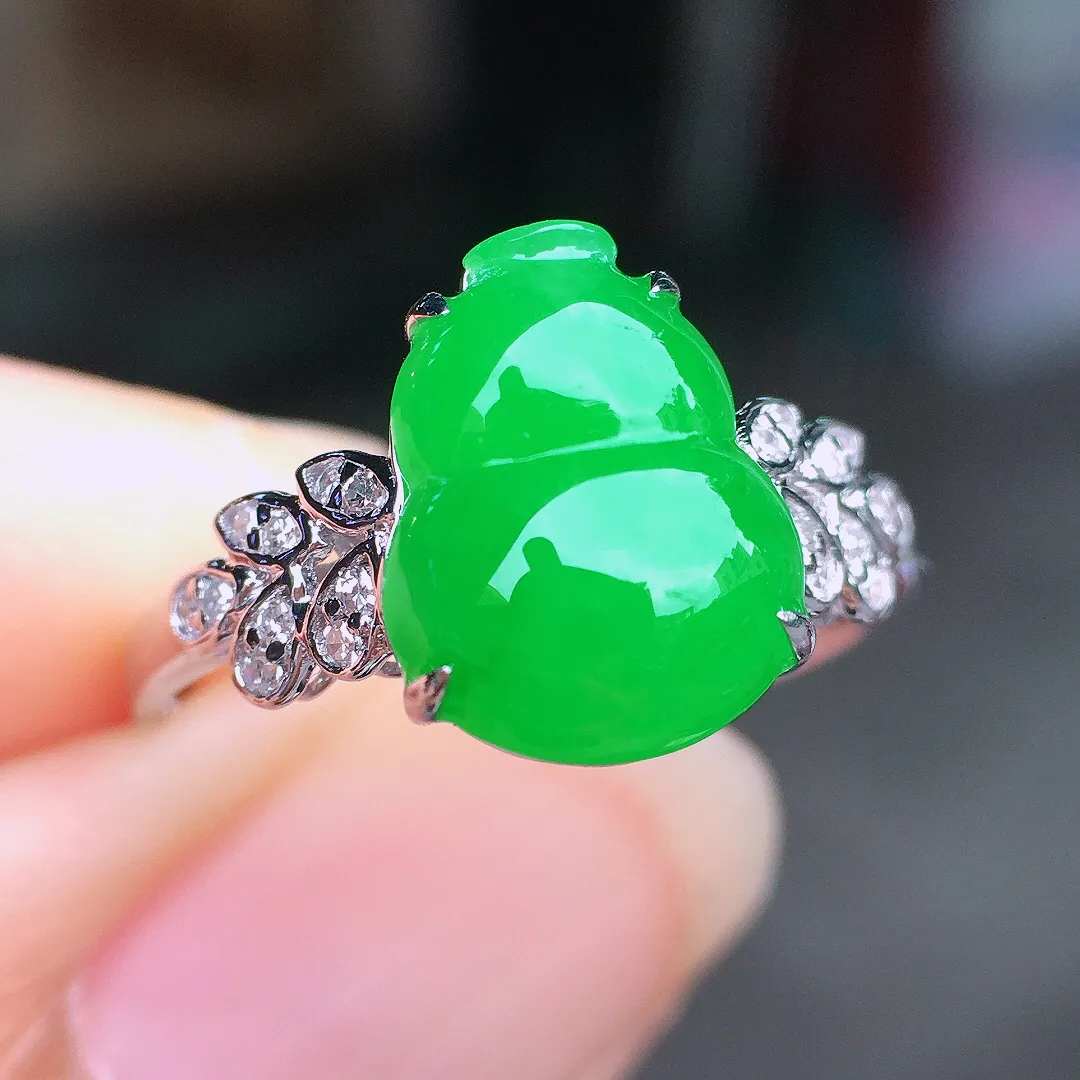 阳绿葫芦戒指，色泽均匀艳丽，玉质细腻，荧光感超
强，饱满圆润，尽显优雅气质，18k
金豪华镶嵌