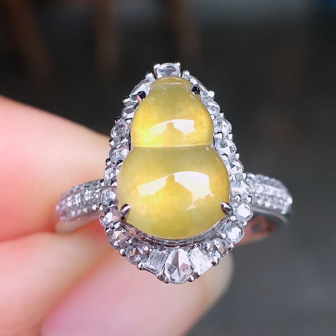 黄翡葫芦戒指，色泽均匀艳丽，玉质细腻，荧光感超
强，饱满圆润，尽显优雅气质，18k
金豪华镶嵌