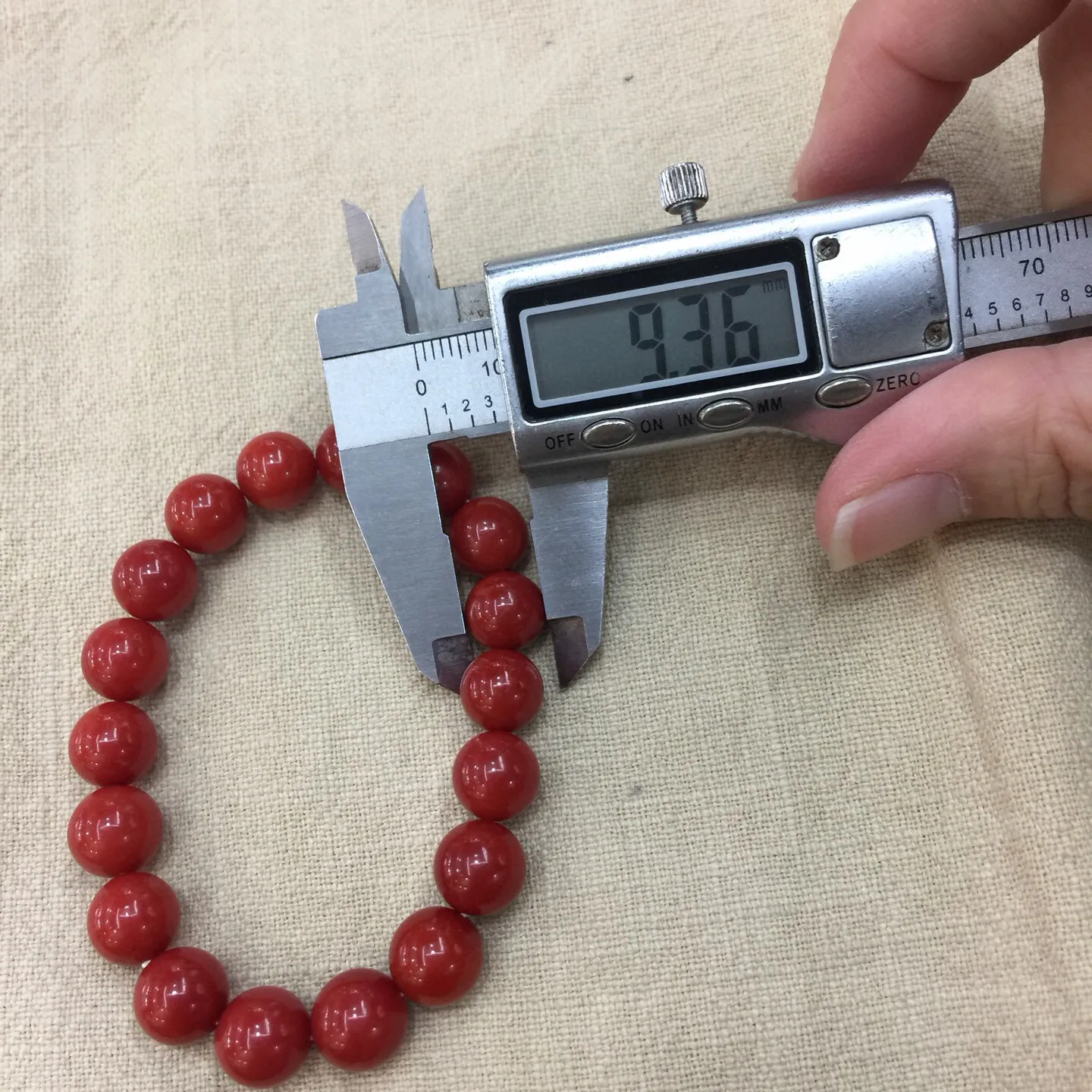 【天然近牛血珊瑚10mm大圆珠弹力手串】近牛血红颜色，光泽柔润透亮，直径约为10.15-9.36mm，重量为23.48克，珊瑚本为佛教珍宝，来自深海千年生长，有生长纹，属于有机宝石，气场强大，材料意大利沙丁材料，稀少珍贵！每粒均为天然无添加无修补！收藏精品！传承宝贝！