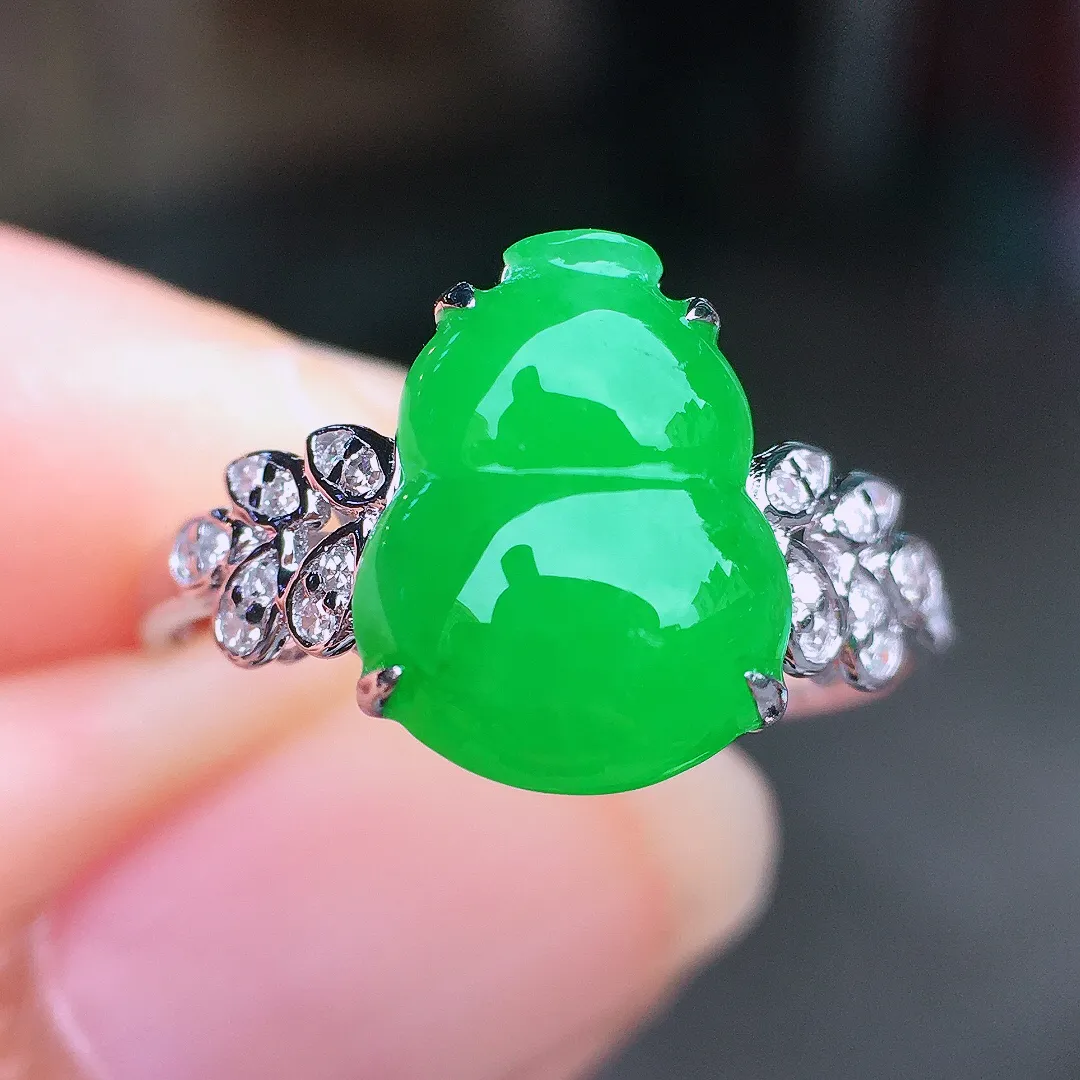 阳绿葫芦戒指，色泽均匀艳丽，玉质细腻，荧光感超
强，饱满圆润，尽显优雅气质，18k
金豪华镶嵌
