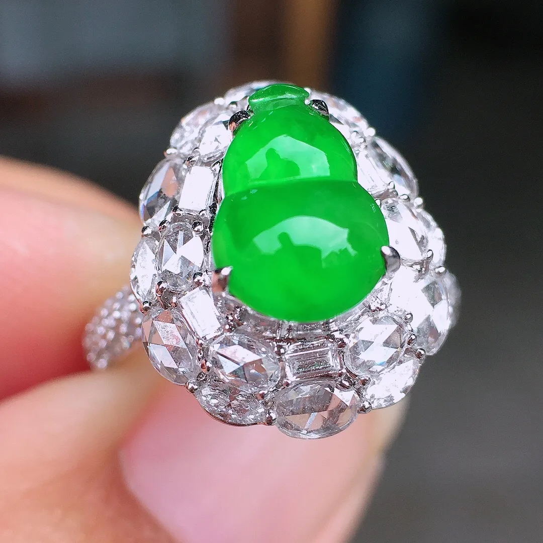 阳绿葫芦戒指，色泽均匀艳丽，玉质细腻，荧光感超
强，饱满圆润，尽显优雅气质，18k
金豪华镶嵌