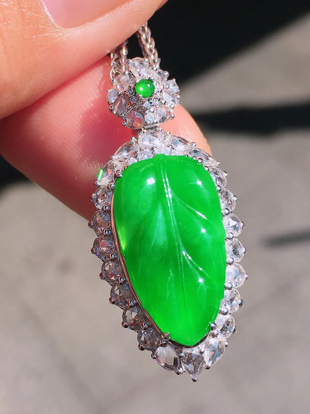 阳绿玉叶吊坠，色泽均匀艳丽，玉质细腻，荧光感超
强，饱满圆润，尽显优雅气质，18k
金豪华镶嵌