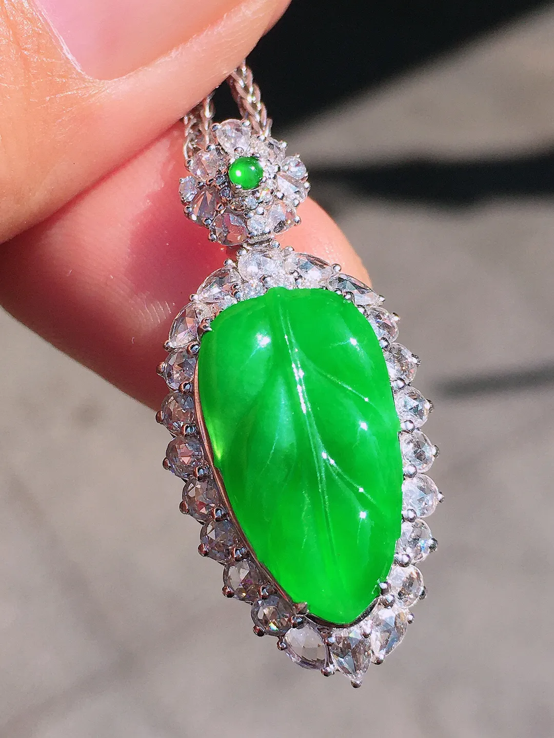 阳绿玉叶吊坠，色泽均匀艳丽，玉质细腻，荧光感超
强，饱满圆润，尽显优雅气质，18k
金豪华镶嵌