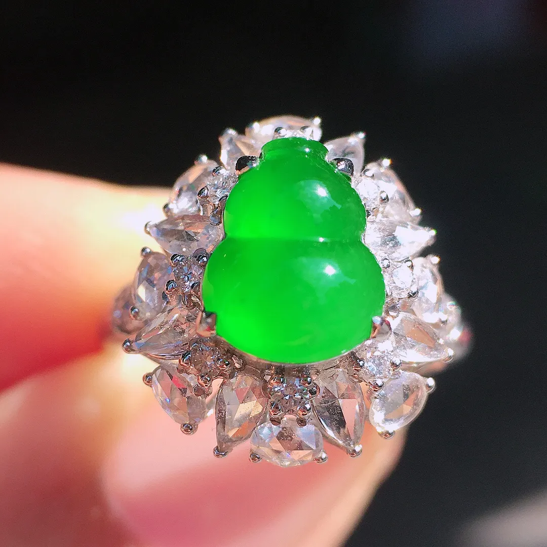 阳绿葫芦戒指，色泽均匀艳丽，玉质细腻，荧光感超
强，饱满圆润，尽显优雅气质，18k
金豪华镶嵌